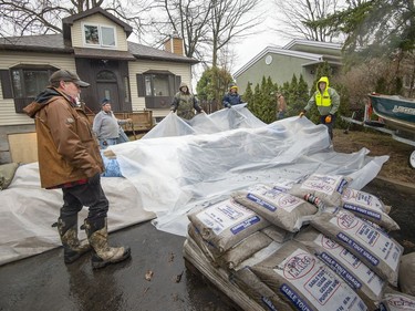 Friends of home owner Andy McCallum on Île Mercier in Pierrefonds help him prepare for the expected flooding from the Rivière des Prairies Friday, April 19, 2019.