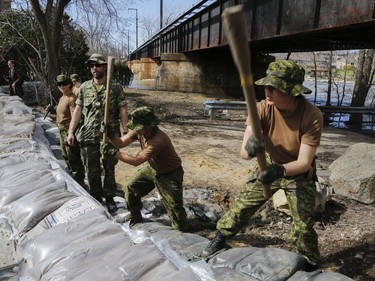 Canadian military personnel construct a wall of sand on Île-Bigras near Montreal on Sunday, April 21, 2019. Premier François Legault was touring areas of Laval affected by rising waters.