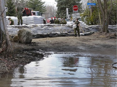 Canadian military personnel construct a wall of sand on Île-Bigras of near Montreal on Sunday, April 21, 2019.