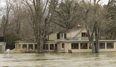 Water from the Rivière des Prairies floods a house on Île-Bigras near Montreal on Sunday, April 21, 2019. Premier François Legault was touring areas of Laval affected by rising waters.