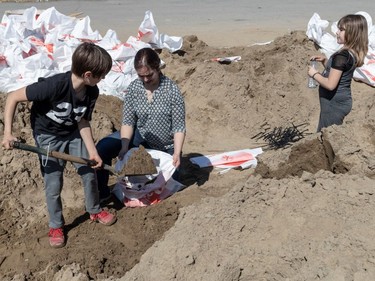 Dominique Robertson, her 11-year-old son Liam Robertson-Zerkler and 9-yer-old daughter Kaitlyn Robertson-Zerkler prepare sand bags at Pierrefonds Comprehensive High School for the spring flooding on Monday April 22, 2019.