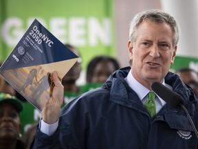 A deal with Hydro-Québec is part of New York City Mayor Bill de Blasio's Green New Deal. He is seen here in N.Y.C. on April 22, 2019 holding up a copy of 'One NYC 2050' as he speaks about the city's response to climate change.