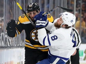 Jake Muzzin of the Toronto Maple Leafs checks Patrice Bergeron of the Boston Bruins into the boards during the first period of Game Five of the Eastern Conference First Round during the 2019 NHL Stanley Cup Playoffs at TD Garden on April 19, 2019, in Boston.