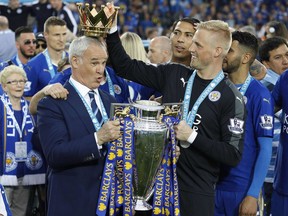 FILE - In this Saturday, May 7, 2016 file photo Leicester City team manager Claudio Ranieri has the crown of the trophy placed on his head by Leicester goalkeeper Kasper Schmeichel as they celebrate becoming the English Premier League soccer champions at King Power stadium in Leicester, England The preseason 5,000-1 title longshots swept the big spending teams aside to win biggest prize in English football Saturday.