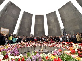 People lay flowers at the Tsitsernakaberd Memorial, on April 24, 2015 in Yerevan, as part of the Armenian genocide centenary commemoration.