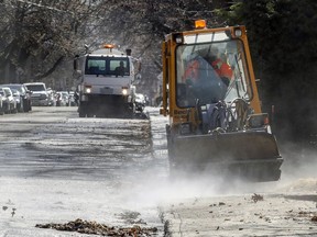 A sidewalk tractor sprays leaves and gravel onto the street to be vacuumed by a street sweeper in N.D.G.
