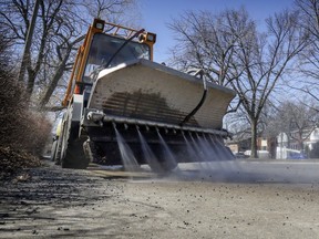 A sidewalk tractor sprays leaves and gravel onto the street to be vacuumed by a street sweeper in N.D.G.