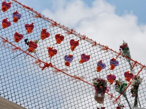 (FILES) In this file photo taken on February 21, 2018 memorials are seen on a fence surrounding Marjory Stoneman Douglas High School in Parkland, Florida. - The community of Parkland was grieving on March 25, 2019 after a second student took their life a little over a year after the shooting at the Florida town's high school which left 17 people dead. As Parkland was mourning, the authorities said the father of a child killed in the 2012 massacre at Sandy Hook Elementary School in Newtown, Connecticut, had apparently committed suicide.Jeremy Richman, 49, lost his six-year-old daughter, Avielle, in the Sandy Hook shooting which left 20 children and six staff members dead.