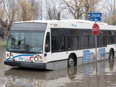 A Gatineau city bus drives through a flooded street in Gatineau, Quebec, on April 20, 2019.