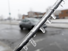 Cars pass a downed telephone line in Laval on Tuesday.