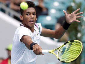 Montrealer Félix Auger-Aliassime returns to John Isner during their semifinal at the Miami Open on Friday, March 29, 2019, in Miami Gardens, Fla.