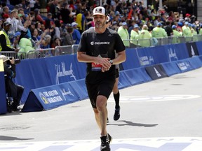 NASCAR driver Jimmie Johnson, of Charlotte, N.C., finishes the 123rd Boston Marathon on Monday, April 15, 2019.