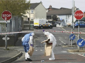 Police forensic officers at the scene in Londonderry, Northern Ireland, Friday April 19, 2019, following the death of 29-year-old journalist Lyra McKee who was shot and killed during overnight rioting.  Police in Northern Ireland said Friday they are investigating the fatal shooting of a journalist during overnight rioting in the city of Londonderry. (Brian Lawless/PA via AP) ORG XMIT: LON814