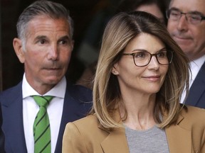 In this April 3, 2019 file photo, actress Lori Loughlin, front, and husband, clothing designer Mossimo Giannulli, left, depart federal court in Boston after facing charges in a nationwide college admissions bribery scandal.