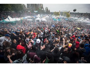 A cloud of smoke hangs over the crowd as thousands of people smoke marijuana during the 420 annual marijuana celebration in Vancouver, on April 20, 2018.