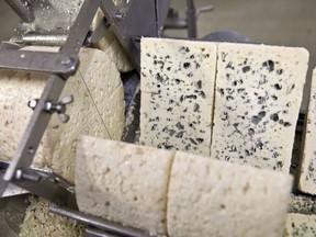 A machine cuts sections of cheese for packaging at the Lebrou-Roquefort plant, part of Groupe Lactalis, in Roquefort, France.