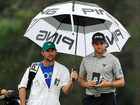 Corey Conners of Canada waits with caddie Kyle Peters on the 18th green during the final round of the Masters on Sunday, April 14, 2019, in Augusta, Ga.