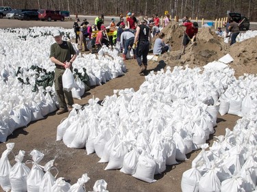 Volunteers at the Constance Bay Community Centre get busy filling sandbags and using them to protect their homes in anticipation of rising water from the Ottawa River.