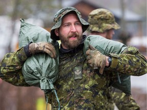 Canadian military hard at work along Bayview Drive as 1RCR from Petawawa beginning assisting with sandbagging in Constance Bay on Friday.