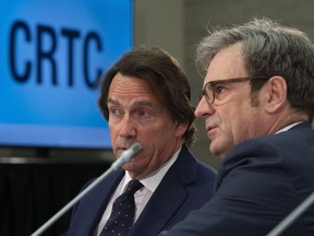 Quebecor President Pierre Karl Peladeau speaks with Chief Operating Officer Mark Tremblay as they wait to appear before Canadian Radio-television and Telecommunications Commission public hearings in Gatineau, Quebec, Wednesday April 17, 2019.
