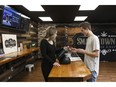 Nicole Felgate helps a customer with a cannabis product at Small Town Buds in Devon, Alta., on Wednesday, April 17, 2019.