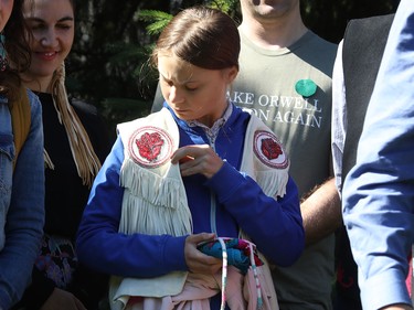 Greta Thunberg looks at the vest presented to her by Perry Bellegarde, Chief of the Assembly of First Nations, at press conference prior to big climate march in Montreal Sept. 27, 2019.