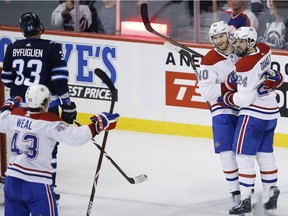 Montreal Canadiens' Jordan Weal (43), Joel Armia (40) and Phillip Danault (24) celebrate Armia's goal on the Winnipeg Jets during first period action in Winnipeg on March 28, 2019.