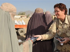 Canadian Sgt. Tanya Casey, a volunteer from Camp Nathan Smith, gives an Eid al-Adha greeting card to an Afghan woman in Kandahar, Afghanistan, in 2009.