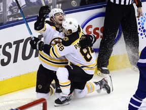 Boston Bruins' Jake DeBrusk (74) celebrates his goal with David Pastrnak (88) during second period NHL playoff hockey action against the Toronto Maple Leafs in Toronto on Sunday, April 21, 2019.