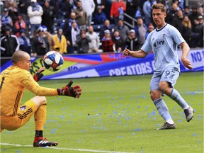 Sporting Kansas City forward Krisztian Nemeth, right, chips the ball over Montreal Impact goalkeeper Evan Bush, left, for his third goal of the match Saturday, March 30, 2019, during an MLS match in Kansas City, Mo. (Ryan Weaver/The Kansas City Star via AP) ORG XMIT: MOKAS104