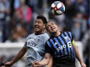 Sporting Kansas City midfielder Roger Espinoza, left, and Montreal Impact midfielder Samuel Piette, right, head the ball during the first half of an MLS soccer match in Kansas City on March 30, 2019.