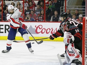 Washington Capitals' Brett Connolly (10) shoots and scores against Carolina Hurricanes goalie Petr Mrazek (34), of the Czech Republic, while Hurricanes Sebastian Aho (20), of Finland, defends during the first period of Game 6 of an NHL hockey first-round playoff series in Raleigh, N.C., Monday, April 22, 2019.