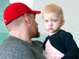 Two-year-old Lyana Deslauriers is held by her father Joel.