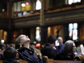 A woman cries as the organs begin to play at Notre Dame Basilica April 16, 2019.