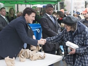 Prime Minister Justin Trudeau speaks to a member of the community as he hands out food at St. Patrick's Church's Good Friday community lunch in Hamilton, Ont., on Friday, April 19, 2019.