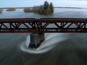 Water from the Rouge River travels under the bridge on Highway 148 near Grenville-sur-la-Rouge on Thursday.