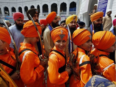 Sikh youth, in traditional dress and holding ceremonial swords, while attending a ceremony during the Vasakhi festival, at the shrine of Gurdwara Punja Sahib, the second most sacred place for Sikhs, in Hasan Abdal, some 50 kilometers (31 Miles) from Islamabad, Pakistan, Sunday, April 14, 2019. Thousands of Sikh pilgrims arrived from neighboring India and other countries to attend the harvest festival that is regionally known by many names and marks the Solar New Year.