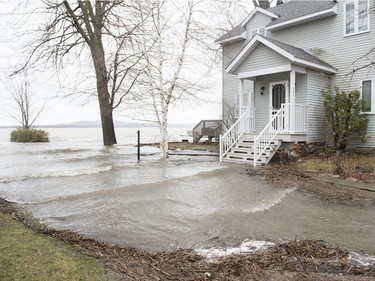 Floodwaters creep towards a home in the town of Hudson, Que. west of Montreal, Saturday, April 20, 2019.