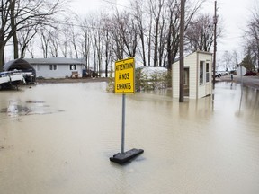 Floodwaters creep closer to homes on a residential street in the town of Rigaud, Saturday, April 20, 2019.