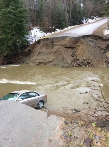 A vehicle is seen in a gaping hole in the road in the Municipality of Pontiac, about 30 km northwest of Ottawa in this photo posted on the Twitter page of MRC des Collines-de-l'Outaouais. One person has died amid flooding in western Quebec, after rising river levels swept away part of a road in the Outaouais region overnight. Police confirmed the death in a tweet Saturday morning, posting a photo of a gaping hole along the road in the Municipality of Pontiac, about 30 km northwest of Ottawa.