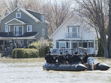 Members of the Naval Reserve patrol the Ottawa river next to homes surrounded by floodwaters in the town of Rigaud, west of Montreal, Monday, April 22, 2019.