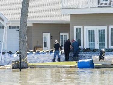 People place sandbags at the river side of their home in the town of Rigaud, west of Montreal, Monday, April 22, 2019.