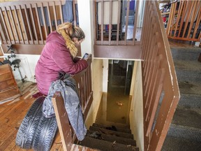 Cynthia Lecompte takes a picture of her flooded basement on Tuesday in Ste.Marthe-sur-le-Lac. Psychologist Pascale Brillon says the trauma suffered by flood victims is unique in that many end up being consumed with anger at the government.