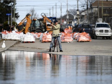 Pierre Bigras, whose father lives nearby, takes a photo from the edge of floodwaters on Rue Saint-Louis in Gatineau, Que., on Monday, April 22, 2019.