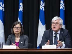 Michel A. Bureau, president of the commission on end of life care, responds to reporters questions at a news conference, Wednesday, April 3, 2019 at the legislature in Quebec City. Quebec Health and Social Services Minister Danielle McCann, left, looks on.