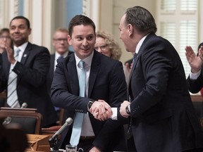 Quebec Minister of Immigration, Diversity and Inclusiveness Simon Jolin-Barrette, left, is congratulated by Quebec Premier Francois Legault after he tabled a Quebec immigration plan for 2019, before question period Tuesday, December 4, 2018 at the legislature in Quebec City.