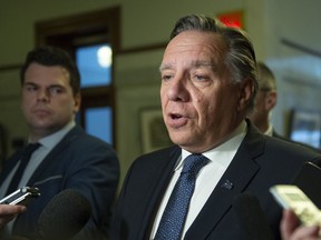 Premier Francois Legault responds to reporters' questions before heading to question period Wednesday, April 3, 2019 at the legislature in Quebec City.