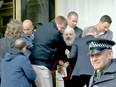 Julian Assange, seen clutching a book by Gore Vidal, is dragged away from the Ecuadorian embassy.