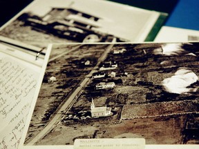 Archived photos on the table in the Forbes building at Lost Villages Museum in Long Sault. The front photo is the remainder of the homes and barns in the village of Moulinette before they were destroyed to create the St. Lawrence Seaway.