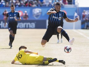 Montreal Impact's Harry Novillo, right, leaps over Columbus Crew SC's Hector Jimenez during first-half action in Montreal on April 13, 2019.